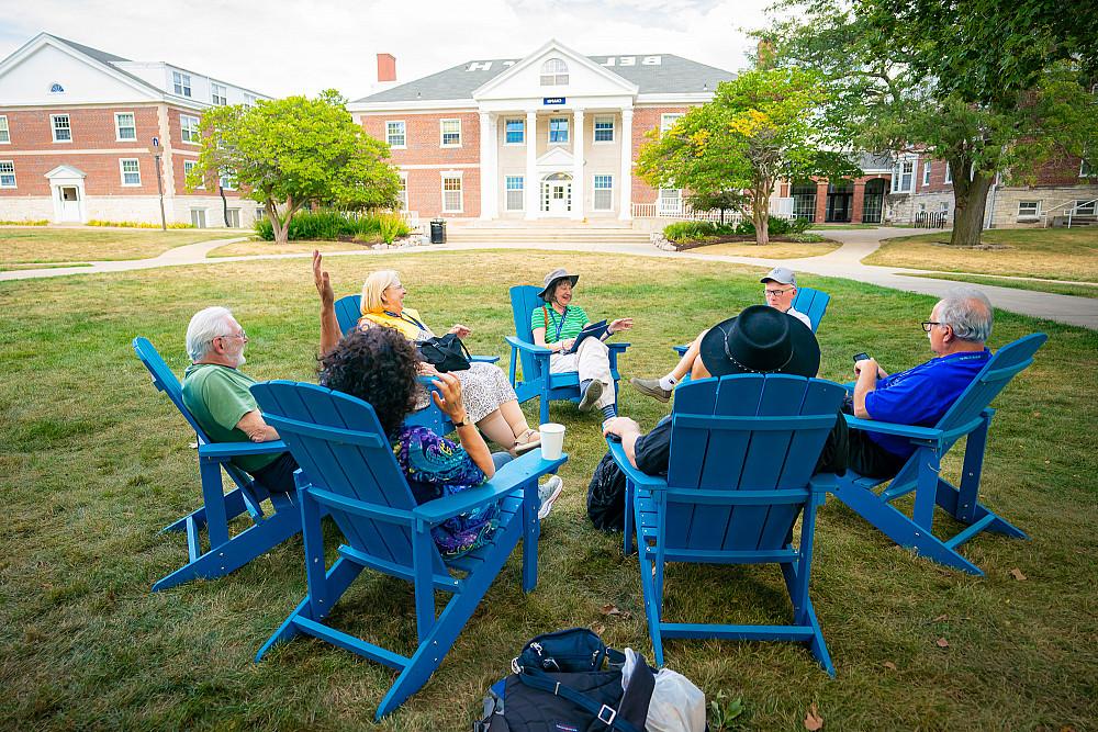 Alums relax and reminisce on Adirondack chairs in Chapin Quad.